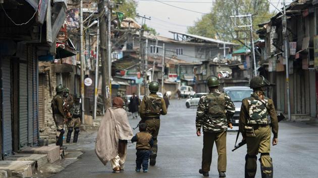 CRPF personnel patrol a street during the third day of strike over the killings of militants and civilians in three separate encounters in Kashmir, in Srinagar, on Tuesday.(PTI Photo)