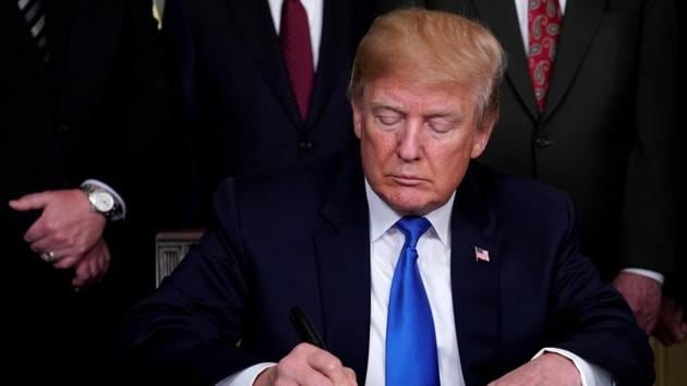 FILE PHOTO: US President Donald Trump signs a memorandum on intellectual property tariffs on high-tech goods from China, March 22.(REUTERS)