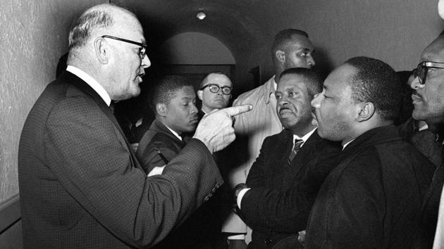 Registrar Carl Golson shakes a finger at the Rev. Dr. Martin Luther King Jr. during meeting at the courthouse in Hayneyville, Alabama on March 1, 1965. King inquired about voter registration procedures but Golson told him that if he was not a prospective voter in Lowndes county, “It's none of your business.” King visited two nearby counties after leading a voter registration drive in Selma. (Horace Cort / AP File) Registrar Carl Golson shakes a finger at the Rev. Dr. Martin Luther King Jr. during meeting at the courthouse in Hayneyville, Alabama on March 1, 1965. King inquired about voter registration procedures but Golson told him that if he was not a prospective voter in Lowndes county, “It's none of your business.” King visited two nearby counties after leading a voter registration drive in Selma. (Horace Cort / AP File)