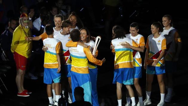Liz Ellis passes the baton to Brent Livermore during the opening ceremony. (REUTERS)