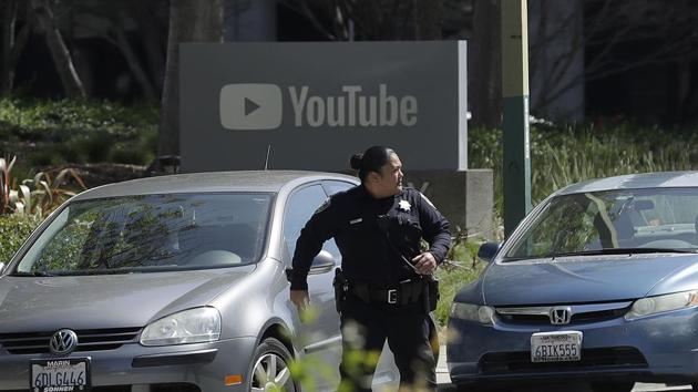 An officer runs past a YouTube sign near the company's complex in San Bruno, California, on April 3, 2018.(AP)