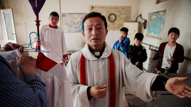 Father Ju Ruibin of the state Catholic church prepares for the Palm Sunday procession. Exact numbers aren’t available, but villagers suggest that the congregations of the official church and Pei Ronggui’s – a retired bishop recognised by Rome and popular among those suspicious of the state church -- were roughly similar, while Dong attracted slightly fewer. (Damir Sagolj / REUTERS)