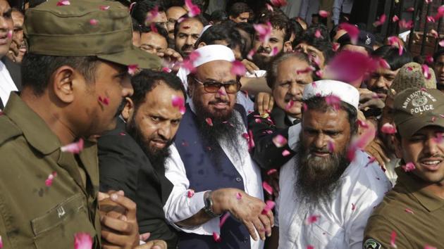 Hafiz Saeed (centre) is showered with rose petals by his supporters as he arrives to a court in Lahore, Pakistan, in October 2017 .(AP File) Hafiz Saeed (centre) is showered with rose petals by his supporters as he arrives to a court in Lahore, Pakistan, in October 2017 .(AP File)