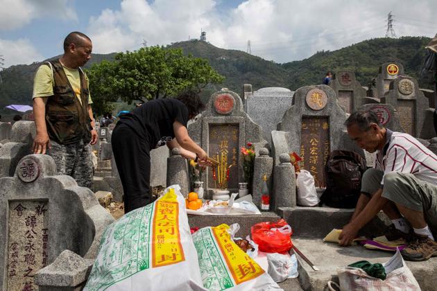 A family pays her respects at the grave of an ancestor in Hong Kong on April 5, 2018.(AFP)