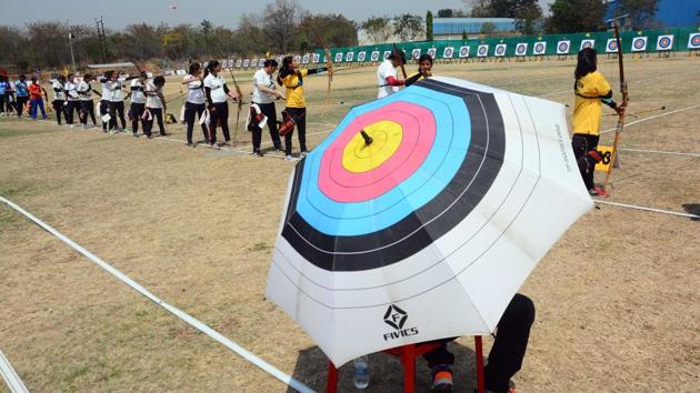 A referee is seen using an umbrella which is a replica of an archery board as participants from various states compete. (Shankar Narayan/HT PHOTO) 