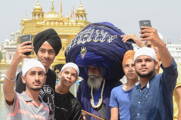 Visitors take a selfie with a Nihang (traditional Sikh religious warrior) Baba Jagir Singh wearing a giant turban at the Golden Temple in Amritsar. (AFP) Visitors take a selfie with a Nihang (traditional Sikh religious warrior) Baba Jagir Singh wearing a giant turban at the Golden Temple in Amritsar. (AFP)