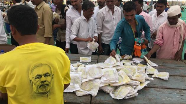 Workers collect food from the free food stall at MMRDA grounds. (bhushan koyande/ht photo)