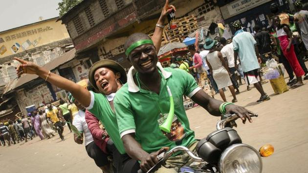 Supporters of opposition presidential candidate Julius Maada Bio celebrate his election victory in Freetown, Sierra Leone. Sierra Leone's former ruling party intends to challenge the results of the presidential runoff vote in court, the losing candidate announced after the opposition party won for the first time in a decade. (Cooper Inveen / AP)