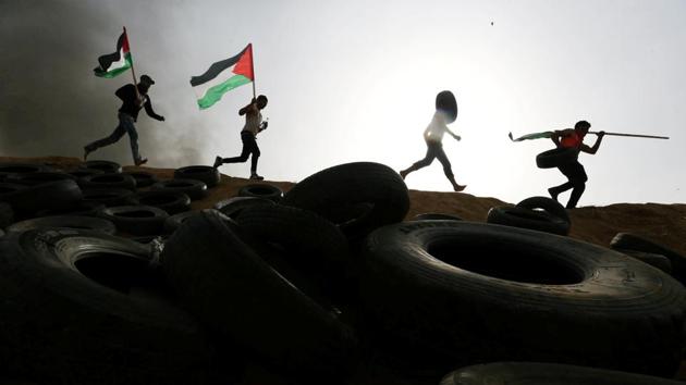 Palestinian protesters run during clashes with Israeli troops as part of an ongoing six week sit-in at Israel-Gaza border, in the southern Gaza Strip. (Ibraheem Abu Mustafa / REUTERS)