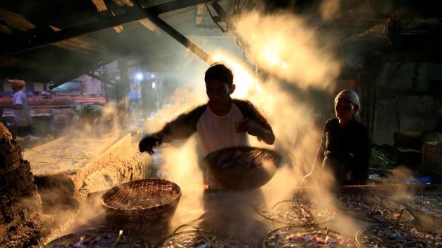 A street vendor is seen marinating fish at Cilincing district in Jakarta, Indonesia. (Beawiharta / REUTERS)