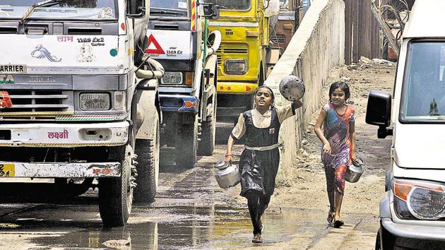 Children run behind water tankers at a water supply depot near Parvati. Parts of the city have been facing acute water shortage, bringing to light the issue of water scarcity which is rising due to rapid urbanisation. (HT PHOTO)