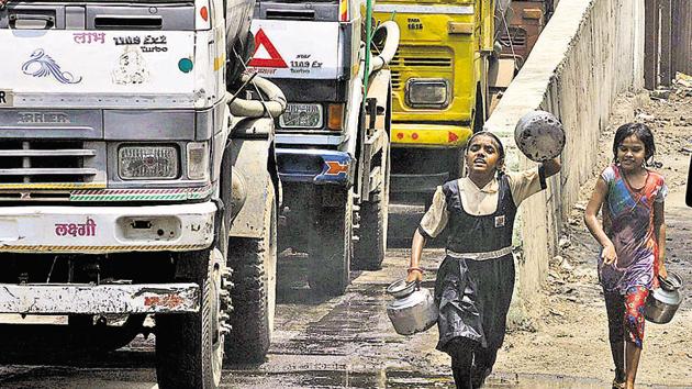 Children run behind water tankers at a water supply depot near Parvati. Parts of the city have been facing acute water shortage, bringing to light the issue of water scarcity which is rising due to rapid urbanisation. (HT PHOTO)