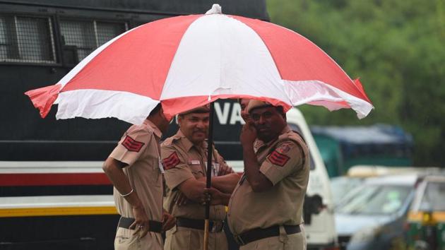 Police personnel huddle under an umbrella during light showers in the city. As per the forecast, similar weather will prevail for the next two days. (Raj K Raj / HT Photo) Police personnel huddle under an umbrella during light showers in the city. As per the forecast, similar weather will prevail for the next two days. (Raj K Raj / HT Photo)