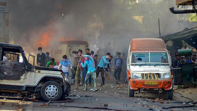 Protestors hurl brickbats near burning cars during 'Bharat Bandh' against the alleged dilution of Scheduled Castes/Scheduled Tribes act, in Muzzaffarnagar, UP.(PTI File Photo)