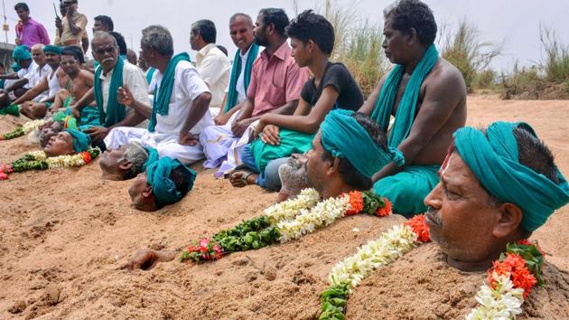Farmers representing National South Indian River Link Association lie neck deep in Cauvery river bed with rose garlands to signify 'death' as part of their protest demanding the constitution of the Cauvery Water Management Board, Tiruchirappalli, Tamil Nadu, April 6 (PTI) Farmers representing National South Indian River Link Association lie neck deep in Cauvery river bed with rose garlands to signify 'death' as part of their protest demanding the constitution of the Cauvery Water Management Board, Tiruchirappalli, Tamil Nadu, April 6 (PTI)