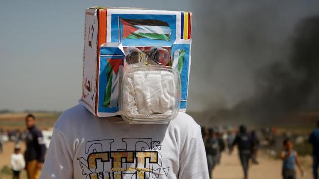 A Palestinian demonstrator covers his face to protect against tear gas during clashes with Israeli security forces. Desperation among Gaza residents has helped drive what Gaza’s Hamas rulers hope will be several weeks of border protests, with the largest crowds expected on Fridays. The idea was initially floated by social media activists, but has been coopted by Hamas. (Mohammed Abed / AFP) A Palestinian demonstrator covers his face to protect against tear gas during clashes with Israeli security forces. Desperation among Gaza residents has helped drive what Gaza’s Hamas rulers hope will be several weeks of border protests, with the largest crowds expected on Fridays. The idea was initially floated by social media activists, but has been coopted by Hamas. (Mohammed Abed / AFP)