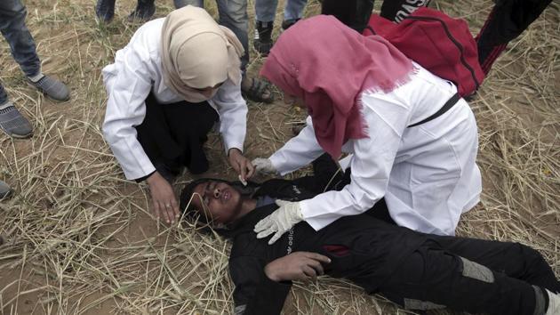 Palestinian medics treat a wounded protester. Israel argues that it has a right to defend its border, alleging that Hamas used protests as cover for trying to damage the border fence, plant explosives and, in one incident, fire on soldiers. Military officials believe Hamas is encouraging people to break through the border. (Khalil Hamra / AP) Palestinian medics treat a wounded protester. Israel argues that it has a right to defend its border, alleging that Hamas used protests as cover for trying to damage the border fence, plant explosives and, in one incident, fire on soldiers. Military officials believe Hamas is encouraging people to break through the border. (Khalil Hamra / AP)