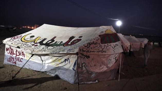 A man walks next to a tent with writing in Arabic that reads, “Palestine,” at a border camp. Employing its organizational prowess, Hamas has set up five camps like this one near border points as a magnet for protesters, offering bus shuttles and monitoring developments from an operations room. (Khalil Hamra / AP) A man walks next to a tent with writing in Arabic that reads, “Palestine,” at a border camp. Employing its organizational prowess, Hamas has set up five camps like this one near border points as a magnet for protesters, offering bus shuttles and monitoring developments from an operations room. (Khalil Hamra / AP)