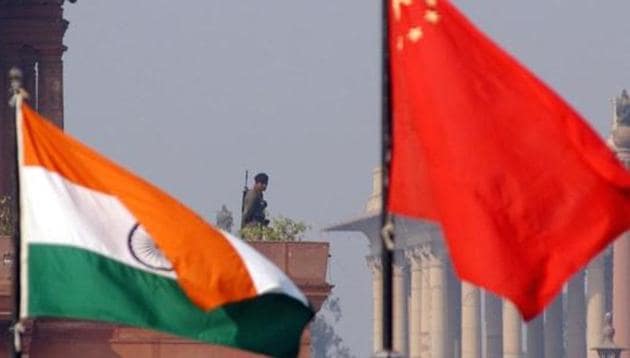 An Indian paramilitary officer is framed by an Indian (L) and Chinese (R) flags as he stands guard near the presidential palace in New Delhi.(AFP FILE) An Indian paramilitary officer is framed by an Indian (L) and Chinese (R) flags as he stands guard near the presidential palace in New Delhi.(AFP FILE)