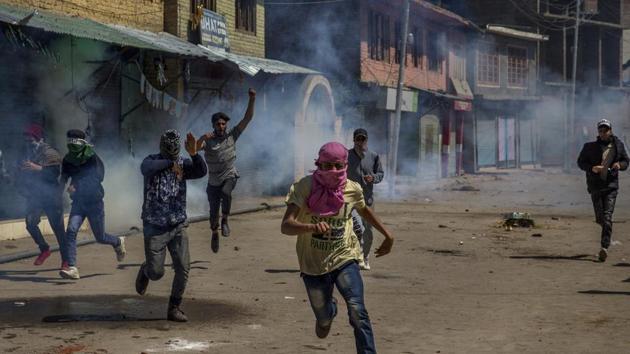 Kashmiri villagers run for cover as government forces fire pellets and tear gas at them after they were stopped from taking part in the funeral procession of Kashmiri militant Mussavir Wani in Pulwama, on April 7.(AP file photo)