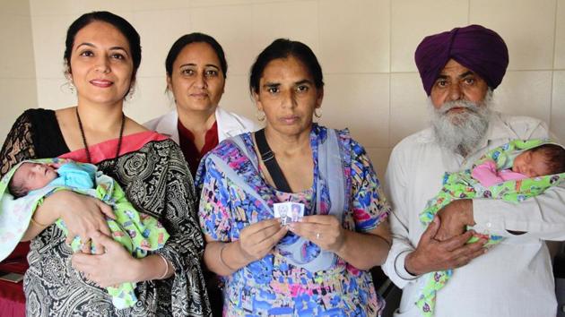 Raikot-based couple Sukhwinder Kaur (50) and Mohinder Singh (65) with twin baby girls in Ludhiana on Monday.(HT Photo)