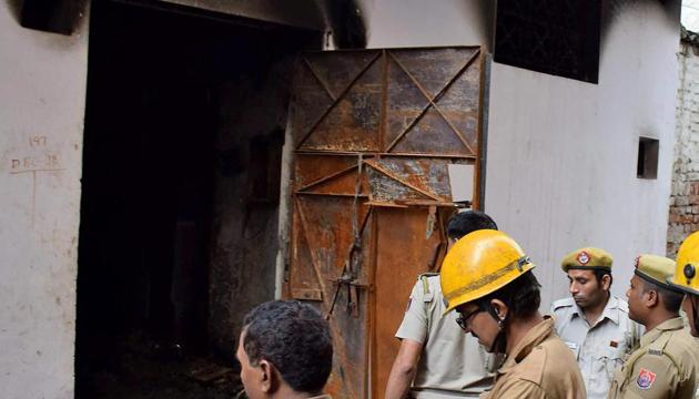 Delhi Fire Service personnel inspect the building of Raja Park factory where a major fire broke out around 6.35 am, in Sultanpuri, New Delhi on Monday.(PTI Photo)