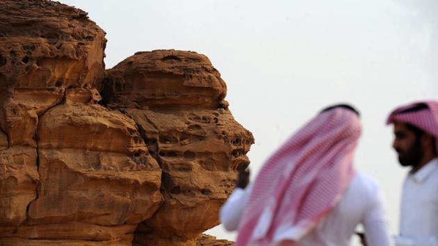 A picture taken on March 31, 2018 shows Saudi men visiting the Khuraiba archaeological site near Saudi Arabia's northwestern town of al-Ula. Al-Ula, an area rich in archaeological remnants, is seen as a jewel in the crown of future Saudi attractions as the austere kingdom prepares to issue tourist visas for the first time.(AFP)