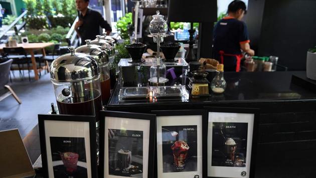 ‘Born’, ‘Elder’, ‘Pain’ and ‘Death’ are just a few of the café’s peachy offerings. The cafe’s owner Veeranut Rojanaprapa says his restaurant is more than just a gimmick or dark take on the cute and cuddly coffee shops common in the Thai capital, which boasts everything from cat, husky and meerkat cafes to unicorn and mermaid-themed eateries. (Lillian Suwanrumpha / AFP) ‘Born’, ‘Elder’, ‘Pain’ and ‘Death’ are just a few of the café’s peachy offerings. The cafe’s owner Veeranut Rojanaprapa says his restaurant is more than just a gimmick or dark take on the cute and cuddly coffee shops common in the Thai capital, which boasts everything from cat, husky and meerkat cafes to unicorn and mermaid-themed eateries. (Lillian Suwanrumpha / AFP)
