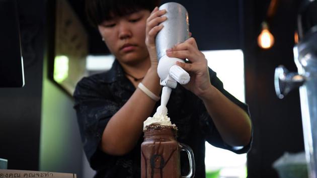 A barista prepares a chocolate milkshake called ‘Death’ at the Kid Mai Death Awareness Cafe. A professor and social researcher, Veeranut conceived of the cafe as a way to teach Thai people -- 90% of whom identify as Buddhist -- about the benefits of “death awareness”. “We found that having an awareness of death decreases greed and anger,” he explained. (Lillian Suwanrumpha / AFP) A barista prepares a chocolate milkshake called ‘Death’ at the Kid Mai Death Awareness Cafe. A professor and social researcher, Veeranut conceived of the cafe as a way to teach Thai people -- 90% of whom identify as Buddhist -- about the benefits of “death awareness”. “We found that having an awareness of death decreases greed and anger,” he explained. (Lillian Suwanrumpha / AFP)