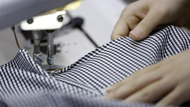 An employee uses a sewing machine while making an Original Stitch shirt at a factory operated by Koyama Choya Sewing Corp., a subsidiary of Yamaki Co., in Saku, Nagano, Japan.(Kiyoshi Ota/Bloomberg)