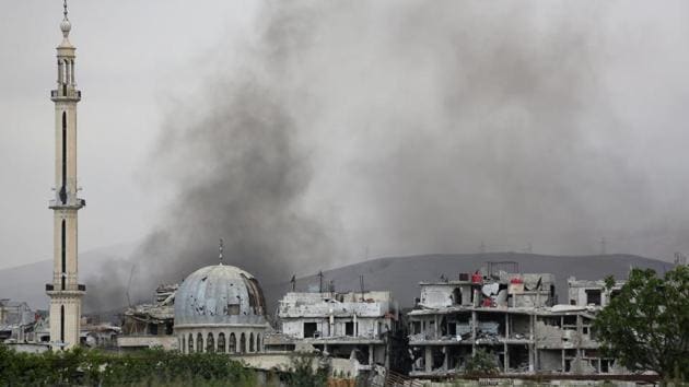 Smoke billows behind destroyed buildings in the former rebel-held town of Saqba in the Eastern Ghouta region on the outskirts of Damascus on Tuesday. (AFP File Photo) Smoke billows behind destroyed buildings in the former rebel-held town of Saqba in the Eastern Ghouta region on the outskirts of Damascus on Tuesday. (AFP File Photo)