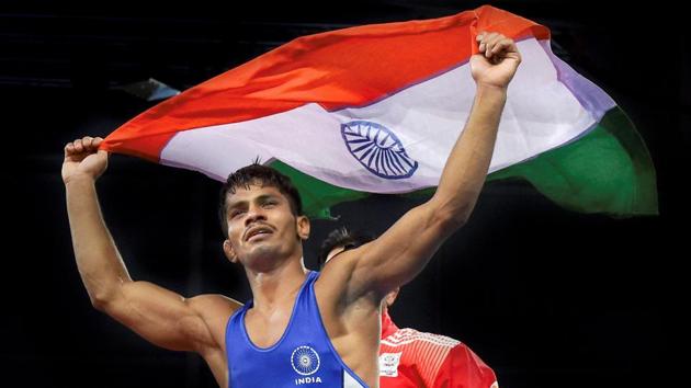 India's Rahul Aware celebrates with the tricolour after winning gold in the 57kg men’s freestyle wrestling division at the 2018 Commonwealth Games in Gold Coast on Thursday.(PTI)