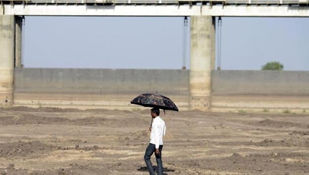 A man walks on dry reservoir bed next to Gunda Dam in Botad district, some 150 km from Ahmedabad in Gujarat state, on April 1, 2016. Report shows shrinking of Sardar Sarovar reservoir in Gujarat.(AFP File Photo)