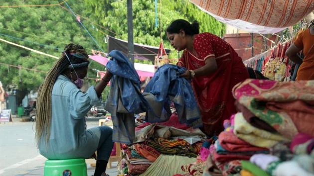 A customer checks out the products at a shop in the Gujarati lane of Janpath Market.(Shivam Saxena/HT Photo)