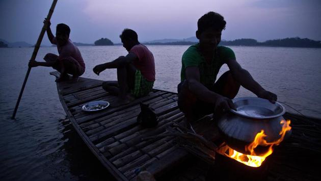 Fishermen prepare food in a fishing boat on the river Brahmaputra in Gauhati on April 9, 2018. (Anupam Nath / AP) Fishermen prepare food in a fishing boat on the river Brahmaputra in Gauhati on April 9, 2018. (Anupam Nath / AP)