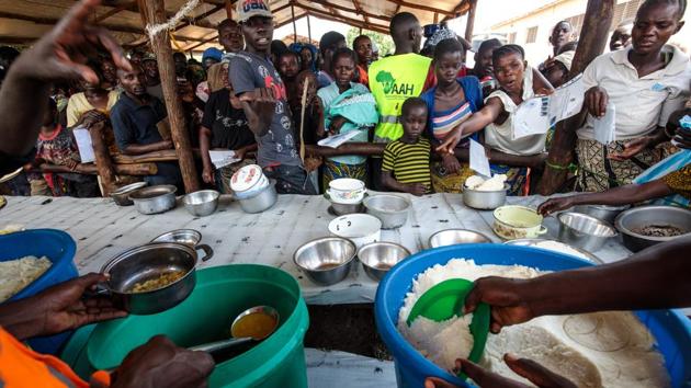 Refugees from the DRC are given a lunch consisting of maize and peas from the World Food Programme by volunteers in the Kyangwali settlement. The World Food Programme anticipates providing food and nutrition for up to 1.6 million refugees this year. (Jack Taylor / Getty Images)