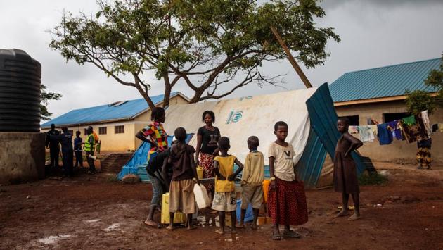 Displaced Congolese children gather by water taps at the reception centre. Waterborne diseases have spread rapidly since mid-February due to poor sanitation and lack of clean water in the camps. (Jack Taylor / Getty Images)