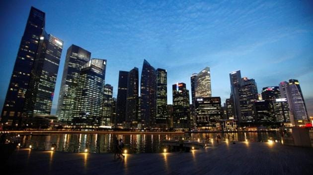 People walk past the skyline of Marina Bay central business district in Singapore.(Reuters File Photo)