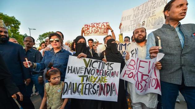 People hold up placards demanding justice for the rape victims of Kathua and Unnao during a candlelight march at the India Gate in New Delhi on Friday. (PTI) People hold up placards demanding justice for the rape victims of Kathua and Unnao during a candlelight march at the India Gate in New Delhi on Friday. (PTI)