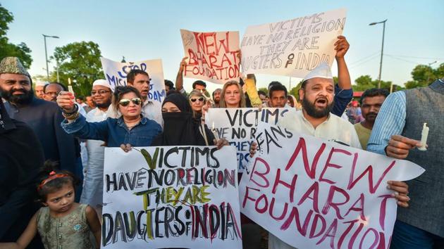 People display a placards as they take part in a candlelight march at the India Gate in protest over Kathua gangrape case in New Delhi on Friday. (PTI Photo) People display a placards as they take part in a candlelight march at the India Gate in protest over Kathua gangrape case in New Delhi on Friday. (PTI Photo)