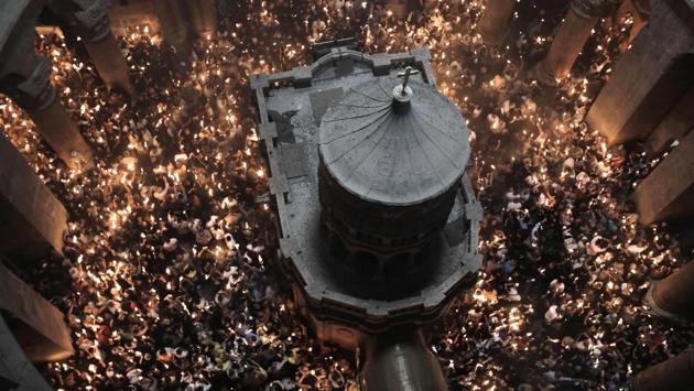Christian Orthodox worshippers hold up candles during the ceremony of the “Holy Fire” as they gather in the Church of the Holy Sepulchre in Jerusalem's Old City, during Orthodox Easter ceremonies. (Menahem Kahana / AFP) Christian Orthodox worshippers hold up candles during the ceremony of the “Holy Fire” as they gather in the Church of the Holy Sepulchre in Jerusalem's Old City, during Orthodox Easter ceremonies. (Menahem Kahana / AFP)