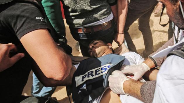 Demonstrators assist an injured Palestinian journalist Yasser Murtaja during clashes with Israeli security forces following a protest near the border with Israel, east of Khan Yunis, in the southern Gaza Strip Murtaja died of his wounds. (Said Khatab / AFP) Demonstrators assist an injured Palestinian journalist Yasser Murtaja during clashes with Israeli security forces following a protest near the border with Israel, east of Khan Yunis, in the southern Gaza Strip Murtaja died of his wounds. (Said Khatab / AFP)