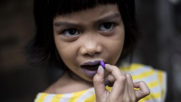 A child uses a candy to color her lips in Manila, Philippines. (Noel Celis / AFP) A child uses a candy to color her lips in Manila, Philippines. (Noel Celis / AFP)