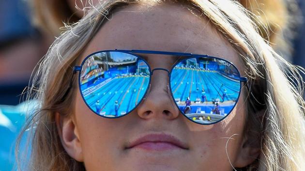 The pool is reflected in the glasses of a spectator during a swimming event at the Optus Aquatic Centre on April 7, 2018. (Manan Vatsyayna / AFP)