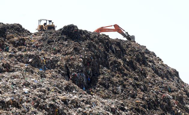 Villagers claim that piles of untreated solid waste at the defunct Bandhwari plant pose grave health risk for them.(Parveen Kumar/HT PHOTO)