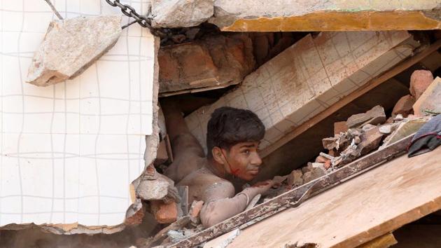 A youth caught in the debris after a building collapsed in Kota on Saturday.(AH Zaidi/HT) A youth caught in the debris after a building collapsed in Kota on Saturday.(AH Zaidi/HT)