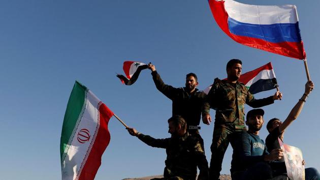 Syrians wave Iranian, Russian and Syrian flags during a protest against U.S.-led air strikes in Damascus,Syria April 14,2018.(REUTERS)