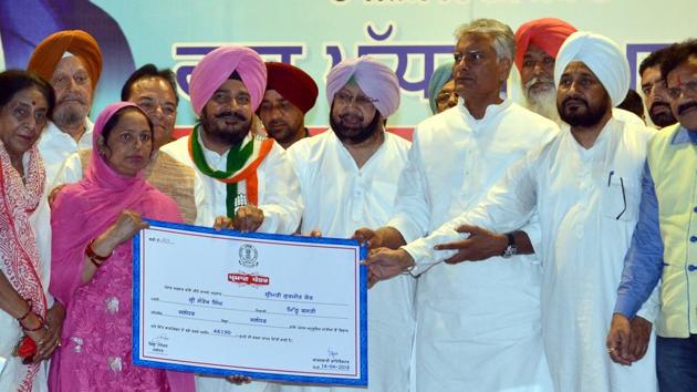 Pradesh Congress Committee (PPCC) president and Gurdaspur MP Sunil Jakhar along with ministers handing over a no-due certificate to waive loans of Scheduled Castes and Backward Classes, in Jalandhar on Saturday.(HT Photo)