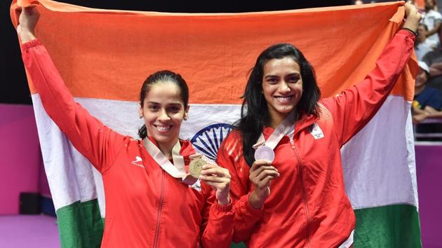 Women's singles gold medallist Saina Nehwal and silver medallist PV Sindhu during the medal ceremony at the 2018 Commonwealth Games in Gold Coast, Australia on Sunday.(PTI)