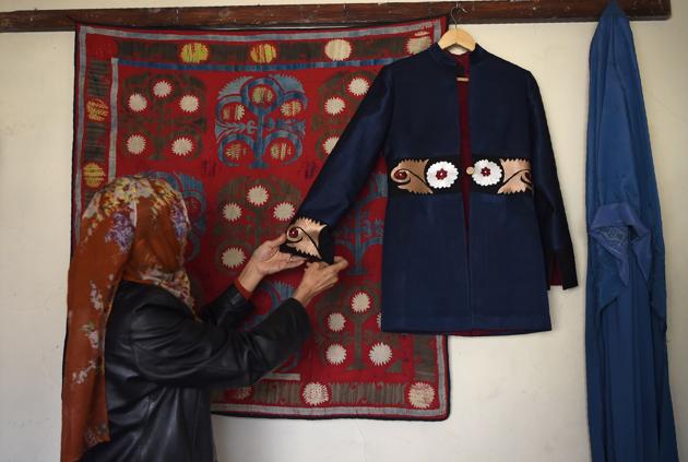 An Afghan tailor hanging an embroidered coat on the wall at Zarif Design House in Kabul. (AFP) An Afghan tailor hanging an embroidered coat on the wall at Zarif Design House in Kabul. (AFP)